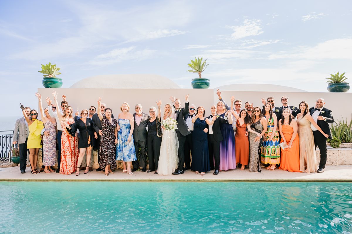 Destination Wedding Guests Group Photo at Villa Magia A joyful group photo with the couple and their guests waving by the pool during a sunny villa magia wedding positano