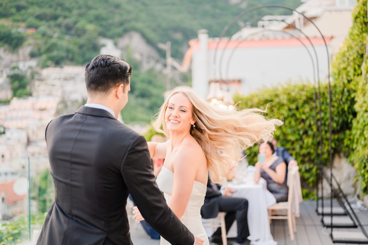 Happy Bride and Groom Dancing in Positano A joyful bride smiles and spins while dancing with the groom at their lively villa magia wedding positano reception on the terrace