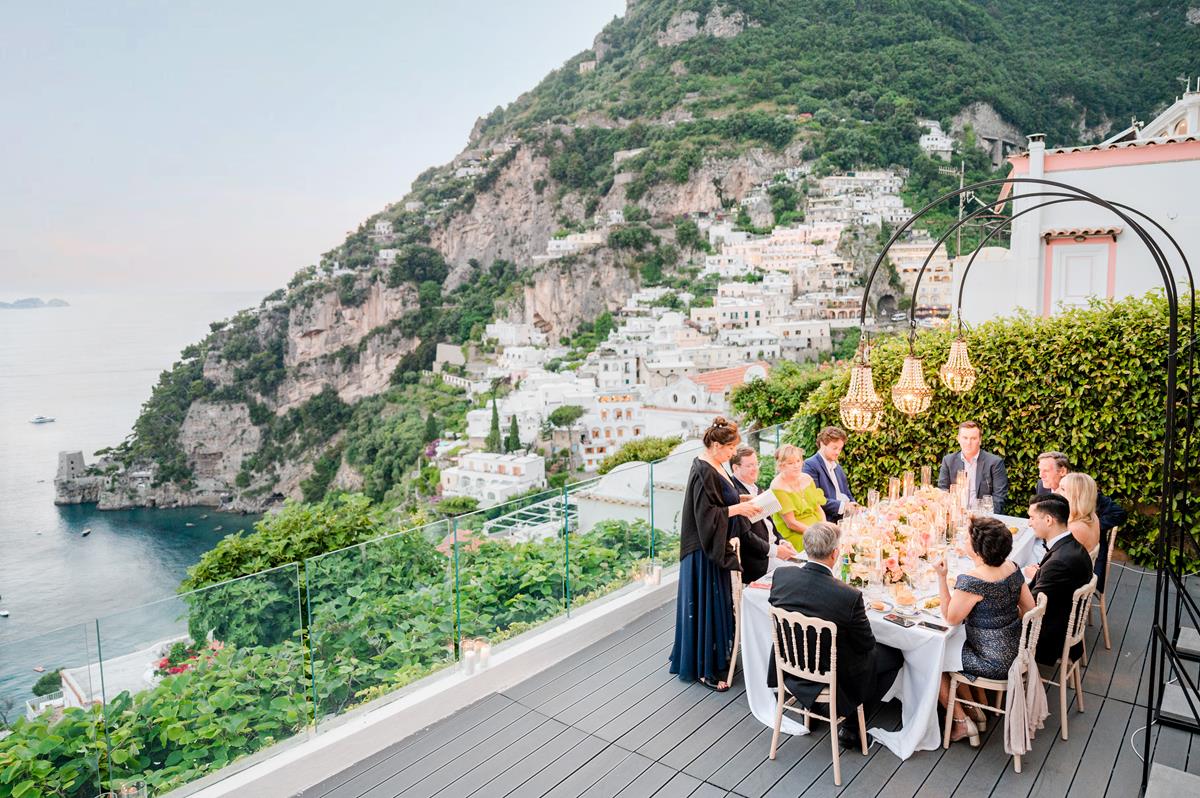 Wedding Dinner with Breathtaking View of Positano Guests enjoying a luxury dinner reception on a terrace during a villa magia wedding positano, with an iconic view of the coast