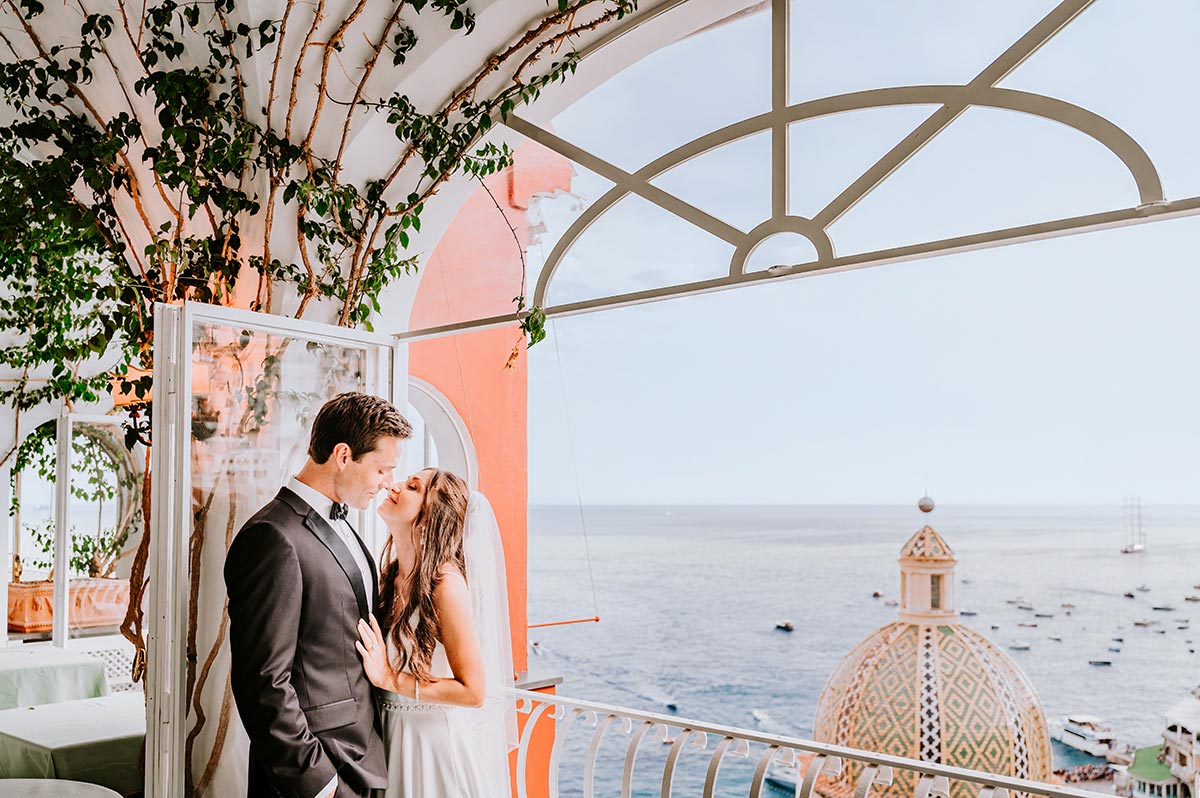 Positano wedding venue with newlyweds on terrace overlooking sea and dome