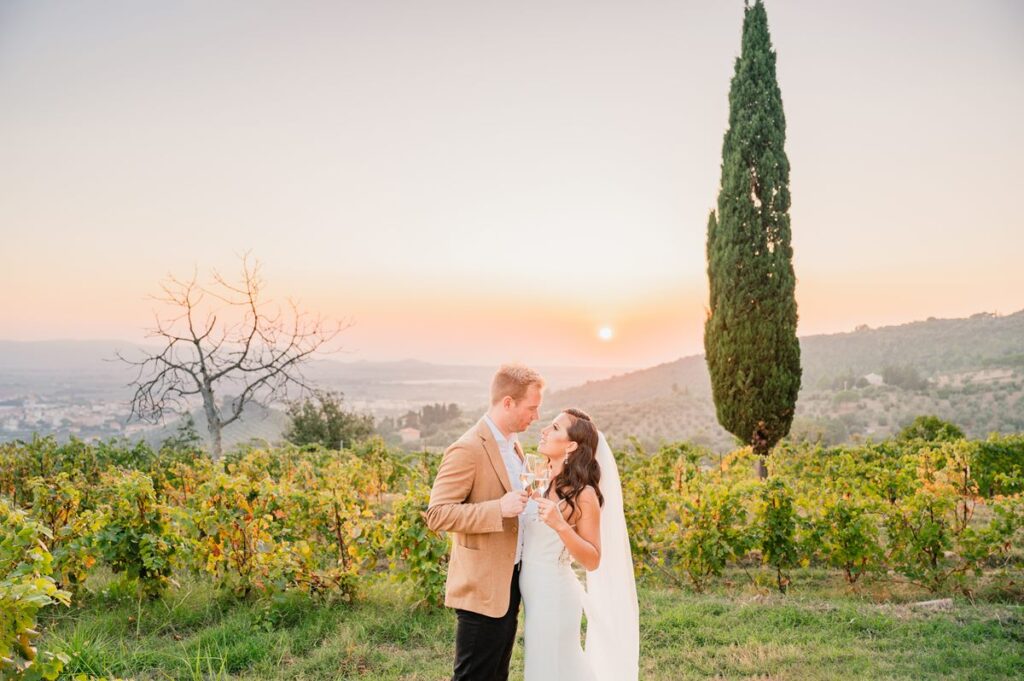 A newlywed couple embraces at sunset in a Chianti wedding venue, surrounded by vineyards and rolling hills