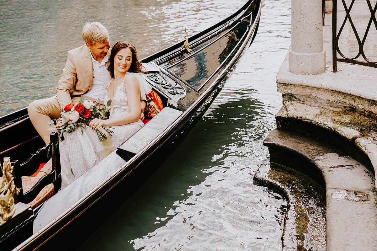Newlyweds enjoying a romantic gondola ride in Venice, arranged by a Venice wedding planner