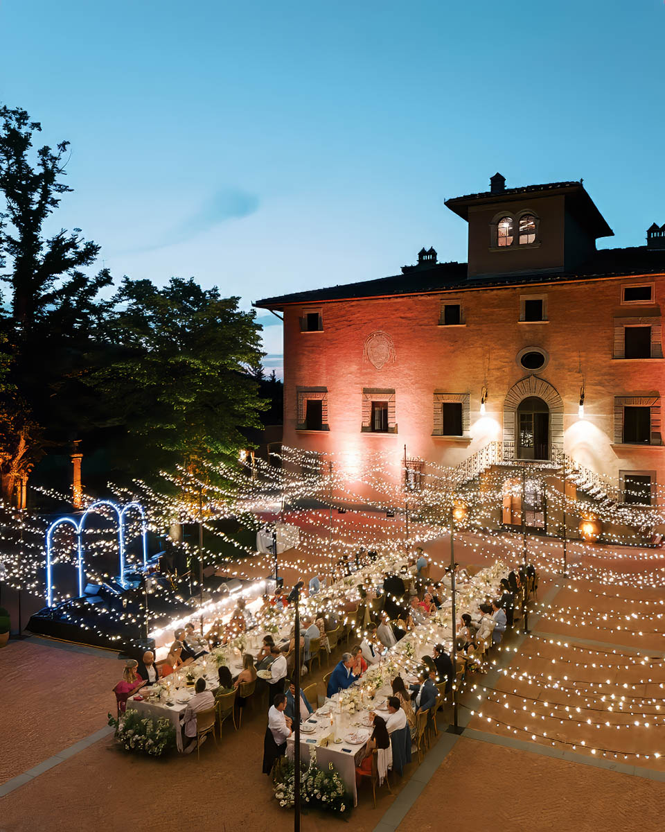 A breathtaking outdoor wedding reception at a Chianti wedding venue, with twinkling string lights and an elegant historic villa