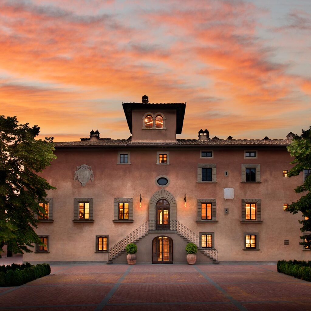 A stunning Chianti wedding venue, featuring a historic Tuscan villa with warm lighting and a picturesque sunset sky