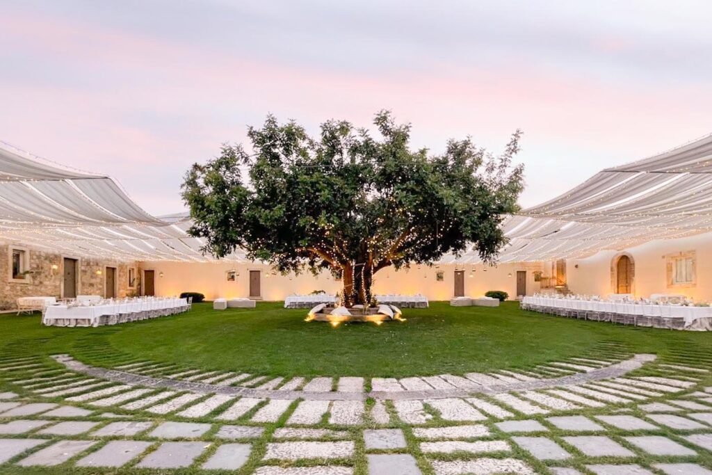 Elegant Sicily wedding venue with a tree centerpiece and draped white canopies