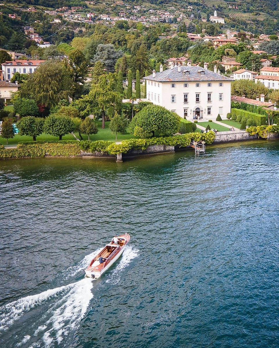 Elegant Lake Como wedding venue with a classic boat arriving at the villa’s private dock